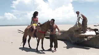 Sexy brunette comes riding and gets fucked by two at the beach