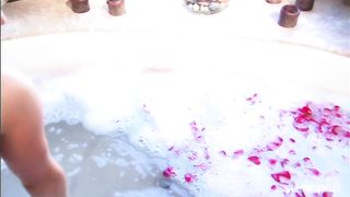 Steamy session with blond and dude in sudsy and rose petal filled tub.